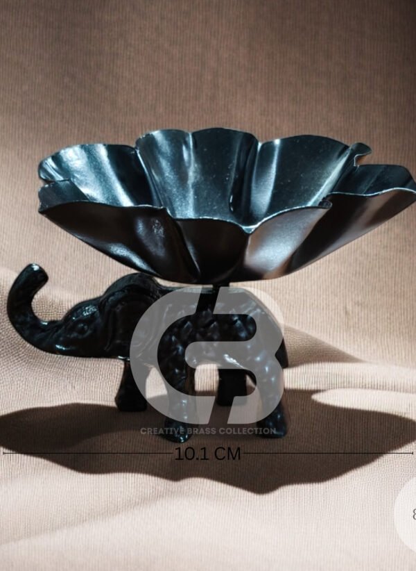 A high-resolution product shot of a handcrafted elephant bowl with colorful enamel details, used as a dry fruit dish. The elephant's trunk is raised in a symbol of good luck. Product code CB-ETLH01.