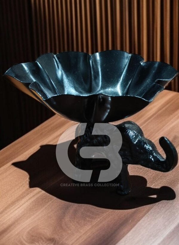 A high-resolution product shot of a handcrafted elephant bowl with colorful enamel details, used as a dry fruit dish. The elephant's trunk is raised in a symbol of good luck. Product code CB-ETLH01.