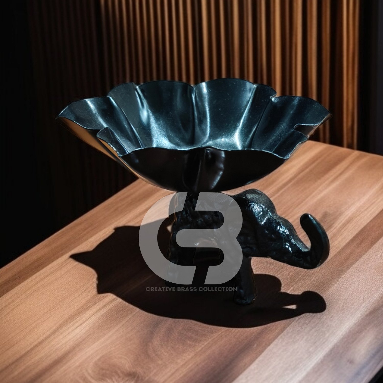 A high-resolution product shot of a handcrafted elephant bowl with colorful enamel details, used as a dry fruit dish. The elephant's trunk is raised in a symbol of good luck. Product code CB-ETLH01.